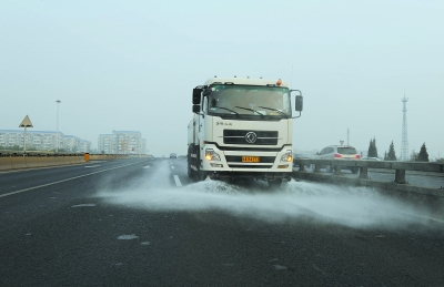 綠化灑水車(chē)正在為路面灑水降溫